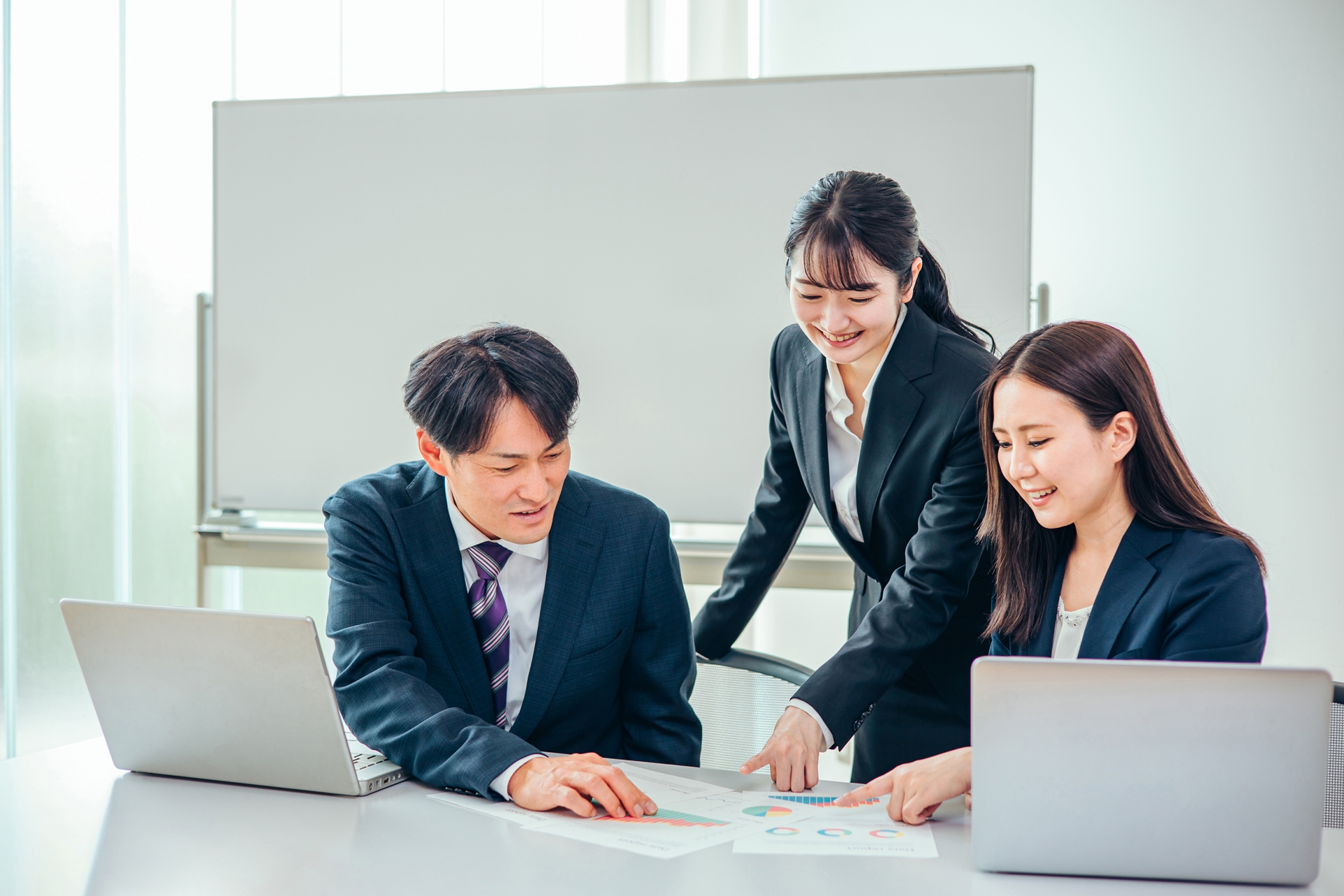 グラフを見ながら話し合う会社員